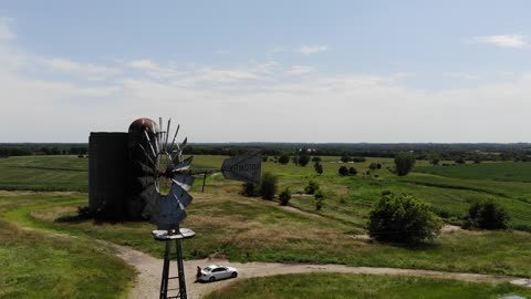 Swivel Around Old Farm Windmill in Green Countryside Under Blue Sky