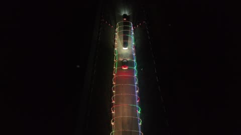 Cars in a Christmas Light Display Park at Night · Flyover