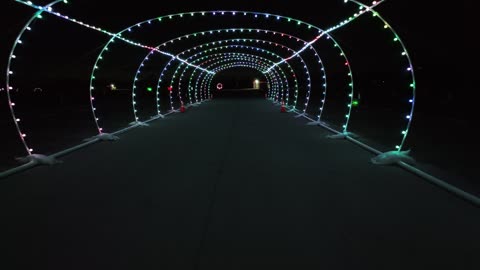 Cars Driving Through a Christmas Light Tunnel Display