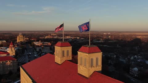 Cupolas and Flags Atop a Historic Building at Sunset