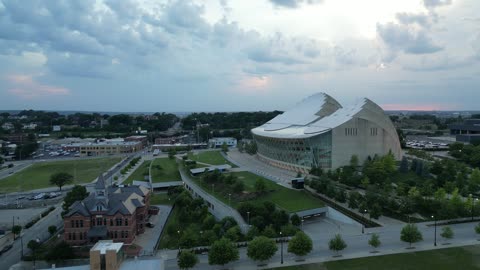 Domed Arena and City Skyline with Smokestacks