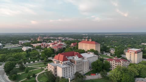 Historic Campus Building with Flags at Sunset