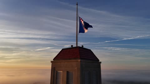 Fraser Hall and Its Flags Above the Morning Mist