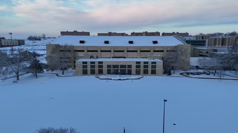 James Naismith Statue at Allen Fieldhouse in Snow · Push-In